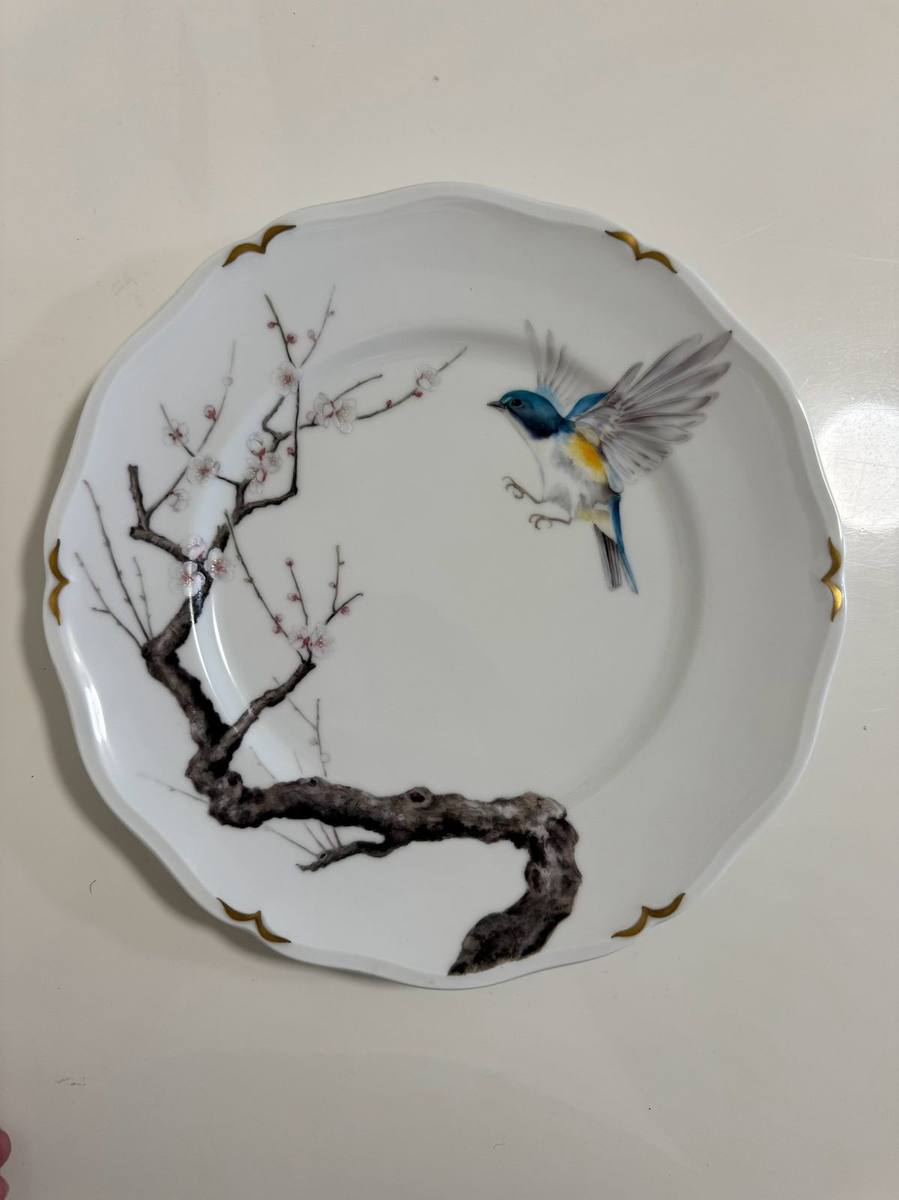 Plate painted with a blue bird flying to a plum branch